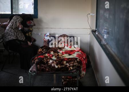 Khan Yunis, Territoires palestiniens. 23 novembre 2023. Des Palestiniens blessés reposent dans une salle de classe de l’école de Ras Al-Naqoura à Khan Yunis, dans le sud de la bande de Gaza, après avoir été transférés de l’hôpital indonésien dans le nord, au milieu des combats en cours entre Israël et le groupe militant palestinien Hamas. Une trêve temporaire convenue par Israël et le Hamas doit commencer vendredi à 7 h (0500 h GMT). Crédit : Mohammed Talatene/dpa/Alamy Live News Banque D'Images