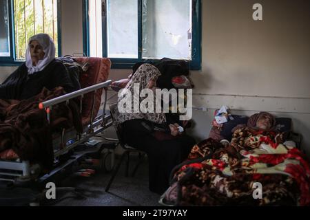 Khan Yunis, Territoires palestiniens. 23 novembre 2023. Des Palestiniens blessés reposent dans une salle de classe de l’école de Ras Al-Naqoura à Khan Yunis, dans le sud de la bande de Gaza, après avoir été transférés de l’hôpital indonésien dans le nord, au milieu des combats en cours entre Israël et le groupe militant palestinien Hamas. Une trêve temporaire convenue par Israël et le Hamas doit commencer vendredi à 7 h (0500 h GMT). Crédit : Mohammed Talatene/dpa/Alamy Live News Banque D'Images