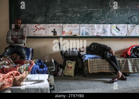 Khan Yunis, Territoires palestiniens. 23 novembre 2023. Des Palestiniens blessés reposent dans une salle de classe de l’école de Ras Al-Naqoura à Khan Yunis, dans le sud de la bande de Gaza, après avoir été transférés de l’hôpital indonésien dans le nord, au milieu des combats en cours entre Israël et le groupe militant palestinien Hamas. Une trêve temporaire convenue par Israël et le Hamas doit commencer vendredi à 7 h (0500 h GMT). Crédit : Mohammed Talatene/dpa/Alamy Live News Banque D'Images