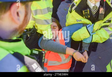 Londres, Royaume-Uni. 23 novembre 2023. Des militants de Just Stop Oil sont arrêtés par des policiers de la Metropolitan police à Whitehall, près de Downing Street. Le groupe d'action pour le climat a marché de Trafalgar Square sur le trottoir et a été arrêté quelques secondes après avoir marché sur la route le quatrième jour consécutif alors qu'ils poursuivaient leurs protestations contre les nouvelles licences de combustibles fossiles. Crédit : Vuk Valcic/Alamy Live News Banque D'Images