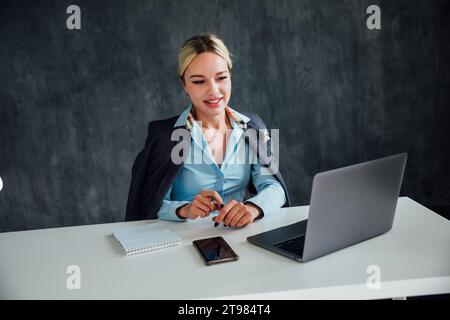 Head shot agréable jeune femme heureuse freelance travaillant sur ordinateur à la maison. Femme d'affaires attrayante étudiant en ligne, . Banque D'Images