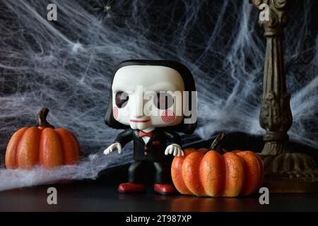 Funko Pop figurine d'action de Billy la marionnette du populaire film d'horreur slasher Saw. Décorations d'Halloween, toile d'araignée, citrouilles, saison sombre, effrayante. Banque D'Images