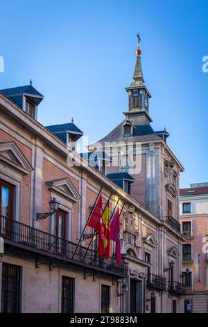 Casa de la Villa à Madrid, Espagne, ancien bâtiment de l'Hôtel de ville avec tour, balcons traditionnels, façade en briques et drapeaux nationaux sur la Plaza de la Villa. Banque D'Images