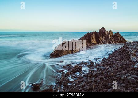 Les vagues de vent s'écrasent sur le rivage rocheux, ciel clair au-dessus de l'océan Atlantique. Banque D'Images