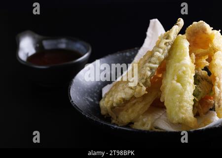 Mélanger le tempura avec les crevettes et les légumes japonais isolés dans un fond noir Banque D'Images