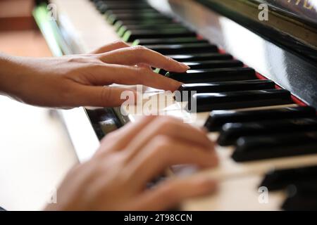 Gros plan de mains féminines jouant une mélodie au piano Banque D'Images