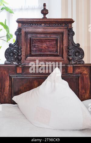 Tête de lit sculptée d'un lit antique en bois massif d'essences précieuses, 19e siècle. Décoré avec rosettes florales sculptées à la main et col décoratif Banque D'Images