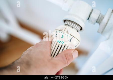 Thermostat du radiateur et main. Chauffage maison en hiver. Économies sur le concept de chauffage. Photo de haute qualité Banque D'Images