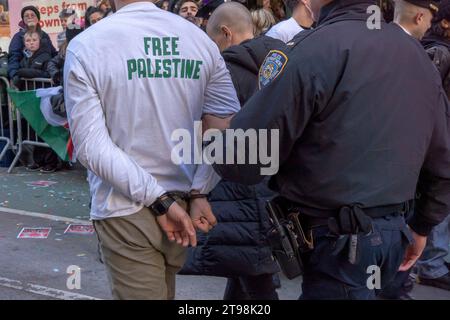 New York, États-Unis. 23 novembre 2023. NEW YORK, NEW YORK - NOVEMBRE 23 : un manifestant est arrêté alors que le défilé du jour de Thanksgiving de Macy était temporairement interrompu après qu'une poignée de manifestants pro-palestiniens ont sauté les barricades et se sont précipités dans la rue le long du parcours du défilé sur la Sixième Avenue le 23 novembre 2023 à New York. Crédit : Ron Adar/Alamy Live News Banque D'Images