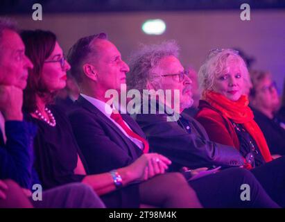 Wittlich, Allemagne. 23 novembre 2023. Le chanteur, peintre et auteur Wolfgang Niedecken (2e à partir de la droite) écoute les louanges de l’ancien président allemand Horst Köhler. A droite, Tina (r), la femme de Niedecken. Niedecken a reçu le prix Georg Meistermann de la ville de Wittlich. Crédit : Harald Tittel/dpa/Alamy Live News Banque D'Images