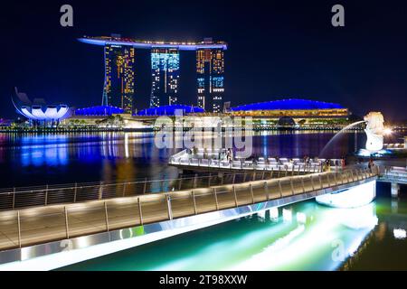 Une vue nocturne de Marina Bay à Singapour, y compris le Marina Bay Sands Hotel, la statue de Merlion et le pont Jubilee, vu depuis Esplanade Drive. Banque D'Images