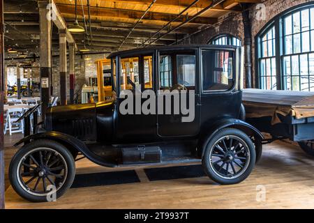 Une Ford Model T noire, fermée, se trouve dans la salle de l'usine Ford Piquette Plant à Detroit, Michigan, États-Unis, devant des rangées de chaises blanches disposées pour un événement. Construit en 1904, le Ford Piquette Plant est considéré comme le plus ancien bâtiment survivant initialement construit pour la production automobile qui reste ouvert au public. Banque D'Images