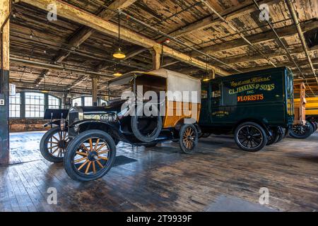 Un camion de livraison historique Ford Model T portant l'inscription "C. L. Jenkins & Fils, Fleuristes" est garé à côté d'un Model T ouvert dans la salle d'usine de la Ford Piquette Plant à Detroit, Michigan, États-Unis. Le slogan "Dis-le avec des fleurs" orne la caisse vert foncé du camion. Construite en 1904, la Ford Piquette Plant est considérée comme le plus ancien bâtiment survivant initialement conçu pour la production automobile et encore ouvert au public. Banque D'Images