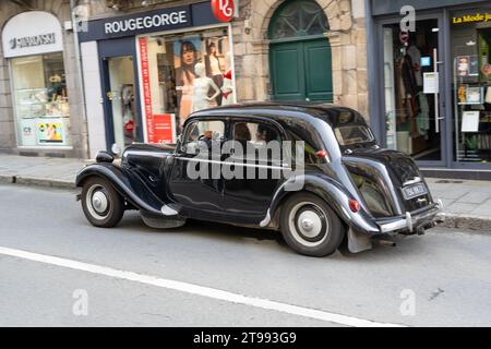 Gros plan d'une voiture Citroen traction avant noire immaculée conduisant le long de la rue principale Banque D'Images