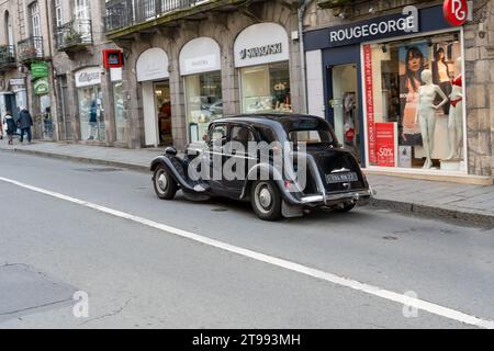 Gros plan d'une voiture Citroen traction avant noire immaculée conduisant le long de la rue principale Banque D'Images