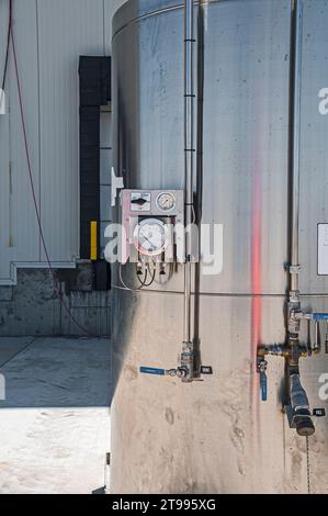 Vue détaillée d'un réservoir en acier inoxydable, à l'extérieur sur une palette métallique dans un entrepôt de réfrigération industrielle au CO2 (stockage frigorifique) en construction. Banque D'Images