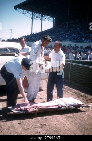 SACRAMENTO, CA - AOÛT 1958 : un groupe d'hommes s'occupe du conducteur après que sa voiture a basculé et s'est écrasé lors d'un salon de l'automobile à la foire de l'État de Sacramento circa août 1958 à Sacramento, Californie. (Photo de Hy Peskin) Banque D'Images