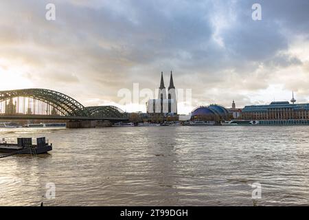 Rhein Hochwasser in Köln beim Pegel von 693 cm aus Sicht des Deutzer Rheinufers, Höhe Kennedy Ufer mit Blick auf die Hohenzollernbrücke, Kölner Dom, musical Dome BEI Sonnenuntergang. 19.11.2023 Köln Deutz NRW Deutschland *** inondation du Rhin à Cologne à un niveau d'eau de 693 cm vu de la rive Deutz du Rhin, à Kennedy Ufer avec vue sur le pont Hohenzollern, la cathédrale de Cologne, le dôme musical au coucher du soleil 19 11 2023 Cologne Deutz NRW Allemagne crédit: Imago/Alamy Live News Banque D'Images