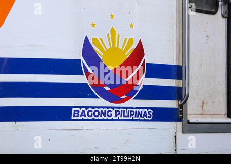 Manille, Philippines. 24 novembre 2023 : logo de la stratégie de marque et de communication du gouvernement philippin “Bagong Pilipinas” publié sous la présidence de Bongbong Marcos affiché sur un train des chemins de fer nationaux philippins (PNR) qui célèbrent aujourd’hui son 131e anniversaire. Les Philippines mettent en œuvre un projet ambitieux d’expansion ferroviaire qui implique l’arrêt des opérations pendant 5 ans dans la région de la capitale nationale (Metro Manila) à partir de janvier 2024, pour laisser place à la construction du projet North-South Commuter Railway (NSCR). Crédit : Kevin Izorce/Alamy Live News Banque D'Images