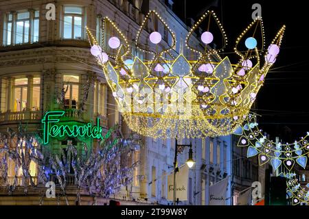 Londres, Royaume-Uni. 23 novembre 2023. Façade du grand magasin Fenwick avec décoration de lumière de rue couronne. Les visiteurs et les acheteurs admirent les boutiques de Noël de New Bond Street et Old Bond Street, qui présentent également des lumières festives inspirées des joyaux de la Couronne. Crédit : Photographie de onzième heure / Alamy Live News Banque D'Images