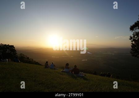 Les gens observent un coucher de soleil orange coloré spectaculaire avec lumière parasite. Rotary Lookout, Tambourin Mountain, Scenic RIM, queensland, Australie Banque D'Images