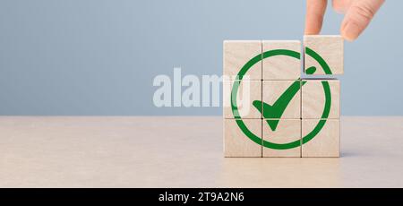 Réglementation et conformité. Réalisation des objectifs et réussite commerciale. Achèvement de la tâche. Entreprise éthique. Qualité et symbole ISO. Cube en bois avec vert Banque D'Images