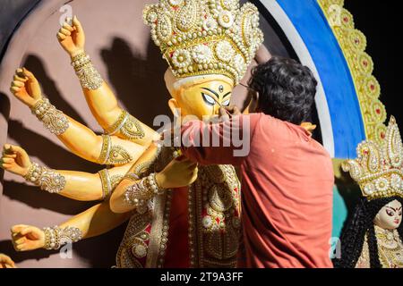 Birbhum, Bengale occidental, Inde - 14 octobre 2023 : un artiste peint les yeux de l'idole Durga avant le festival de la puja Banque D'Images