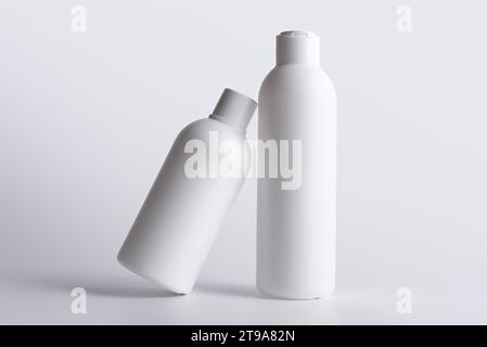 Deux bouteilles blanches pour gel, shampooing, savon ou autres produits cosmétiques sur fond blanc. Maquette de conteneurs pour la marque. Banque D'Images