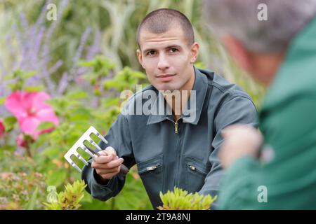 Homme de flou artistique le ratissage des feuilles au jardin Banque D'Images