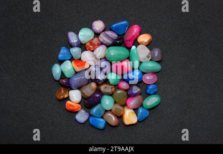 Bouquet de pierres de quartz semi-précieuses traitées et polies sur une surface noire vue de dessus Banque D'Images