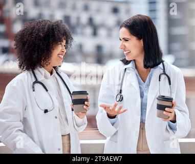 Conversation, café et jeunes femmes médecins parlant sur le diagnostic médical sur le toit de l'hôpital. Sourire, discussion et travailleuses de la santé Banque D'Images