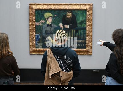 Berlin, Allemagne - 03 novembre 2022 : personnes observant 'dans le Conservatoire', 1879 peinture à l'huile d'Edouard Manet à l'Alte Nationalgalerie à Berlin. Banque D'Images