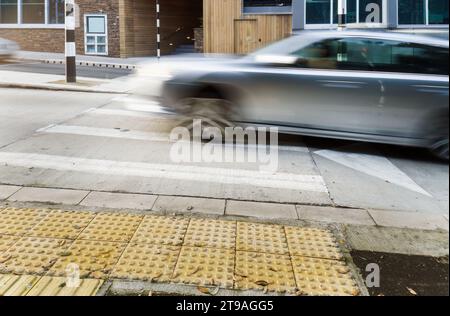 Voiture grise conduisant à la bosse de vitesse et passage pour piétons à Auckland. Banque D'Images