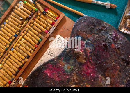 Une Palette peint, pastels, peinture et pinceaux dans un ancien studio d'artistes Banque D'Images