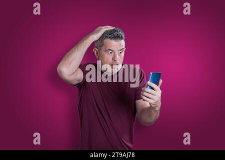 Homme sérieux confus utilisant un téléphone portable. Concept d'émotion Banque D'Images