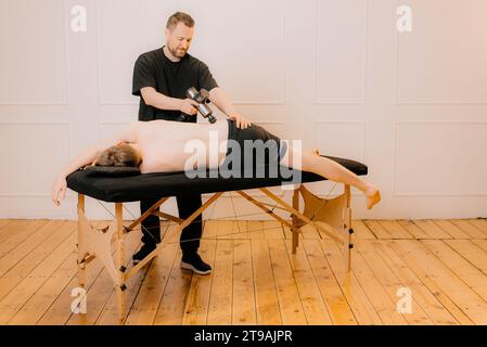 Homme médecin professionnel ostéopathe fixant et étirant les hommes en arrière avec les mains pendant l'effort à la théapy de réadaptation dans la clinique de thérapie manuelle, top Banque D'Images