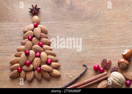 Arbre de Noël en amandes décoré de canneberges sur fond en bois, concept de nourriture de noël Banque D'Images