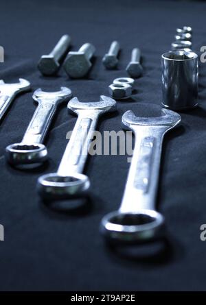 Embouts de clé à douille en métal, boulons à vis et clés en acier dans Une photo stock verticale de comparaison de taille Banque D'Images