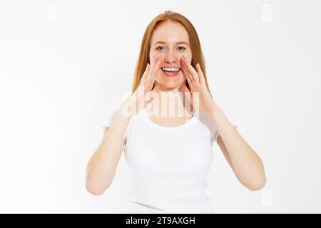 Jeune femme racontant quelque chose, fille à tête rouge racontant un secret. Portrait jeune femme heureuse qui appelle à quelqu'un. Drôle de modèle de fille chuchotant sur Banque D'Images