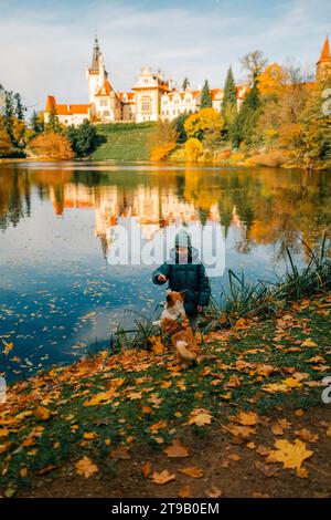 Un garçon avec un chien corgi près du lac dans le château de Pruhonice Banque D'Images