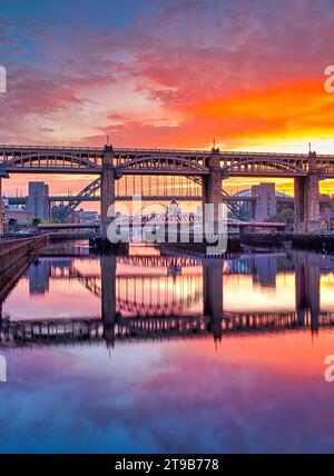 Lever du soleil sur le quai de Newcastle en été regardant en aval des ponts de Tyne Banque D'Images