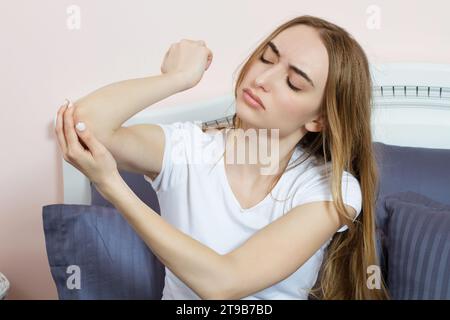 Soins de santé et concept médical. Femme se grattant le coude. Femme se grattant le bras et le coude à cause de la peau sèche à la maison. Banque D'Images