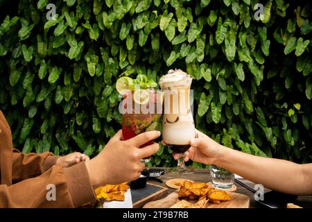 Cette image résume les plaisirs variés de siroter un délicieux milkshake au café et de savourer les notes revigorantes d'un cocktail classique. Banque D'Images