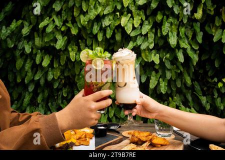 Cette image résume les plaisirs variés de siroter un délicieux milkshake au café et de savourer les notes revigorantes d'un cocktail classique. Banque D'Images