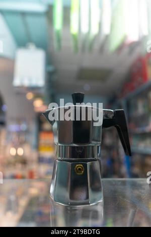 Cafetière italienne en acier inoxydable, élégamment conçue pour préparer un expresso riche et aromatique. Parfait pour les scènes de café à la mode et les visuels de brassage maison. Banque D'Images