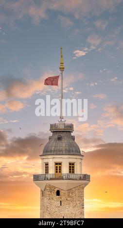 La Tour de la Maiden ou Kiz Kulesi, un monument emblématique d'Istanbul, en Turquie, est captivant dans les teintes chaudes d'un soleil couchant. Le vibrant drapeau turc flotte au sommet de la tour Banque D'Images