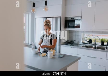 Young woman baking in kitchen Banque D'Images