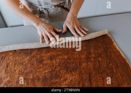 Vue à angle élevé des mains d'une femme qui roule la pâte Banque D'Images