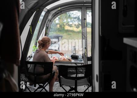 Femme préparant le repas en camping-car Banque D'Images