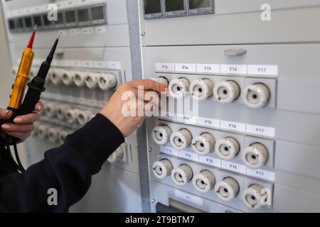 Main d'une technicien faisant fonctionner la boîte à fusibles électrique Banque D'Images